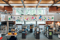 Bücherregale in der Bücherhalle Bramfeld und verschiedene Blumenbilder auf einer Galerie