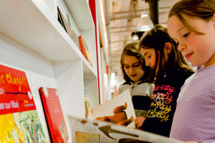 Drei Mädchen sehen sich Bücher an