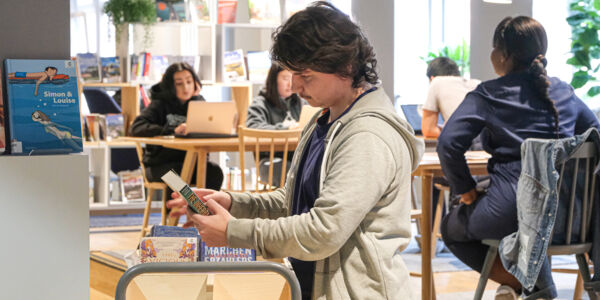 Mann blickt auf Buch in Bibliothek