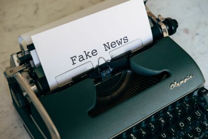 Schreibmaschine mit eingespanntem Blatt Papier auf dem "Fake News" geschrieben steht