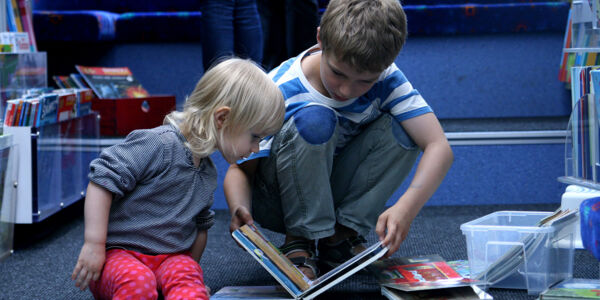 Kinder sehen sich Bücher an im Hamburger Bücherbus